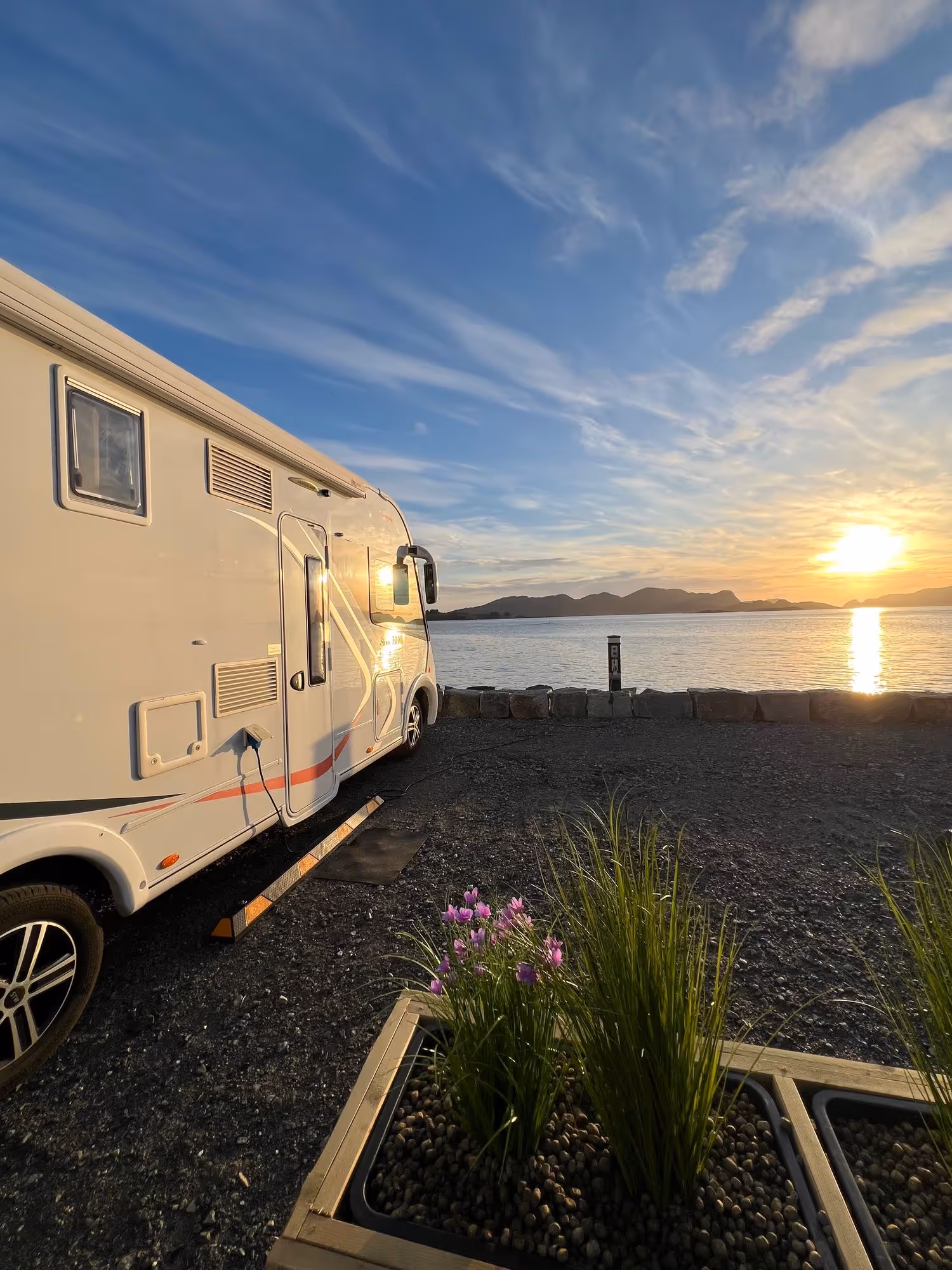Bobil ved fjorden i varm kveldssol